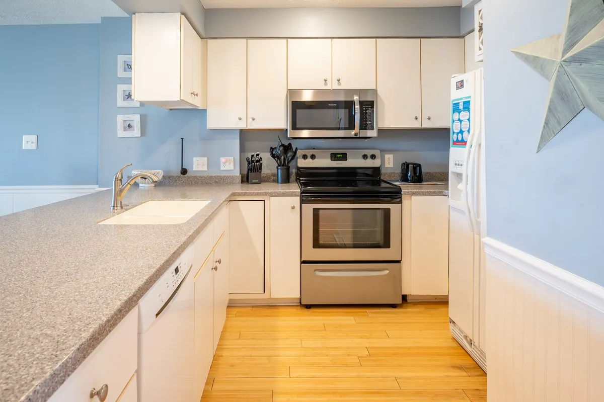 A modern kitchen with full-size stainless steel appliances, generous counter space, and a distinctive star decoration above the counters. The area is bright and welcoming, perfect for cooking and entertaining. Subtle decor and functional layout set the tone for shared culinary activities.